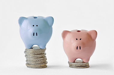 wage gap demonstrated by a blue piggy bank and pink piggy bank